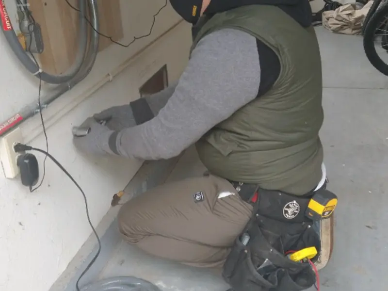 Electrician performing outlet wiring in a Keizer garage